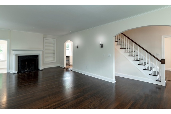 Unfurnished living room with dark wood-type flooring, plenty of natural light, and built in features
