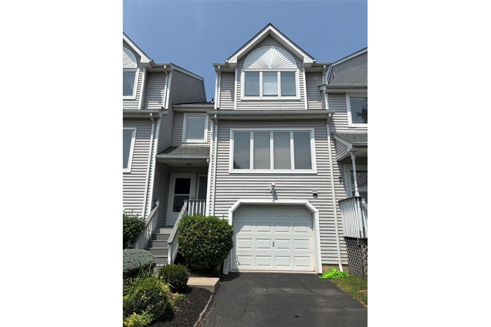 View of front of property featuring an attached garage and driveway
