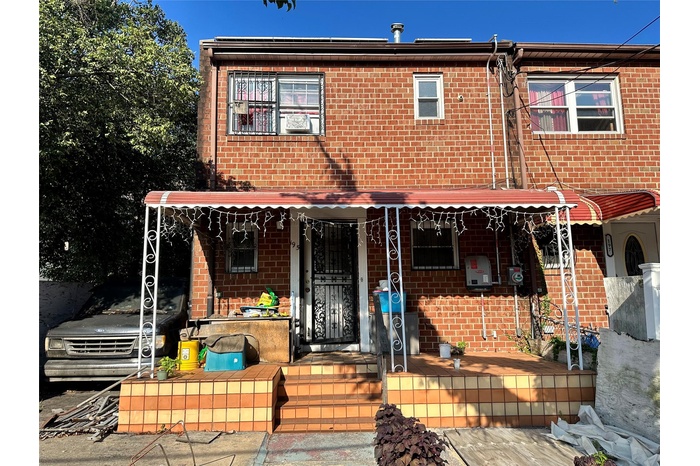 View of front facade featuring brick siding and covered porch