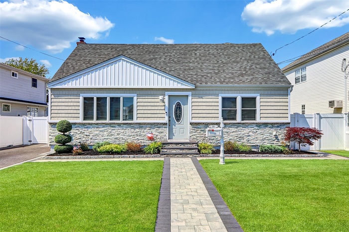 Bungalow-style home with a gate, stone siding, roof with shingles, and cooling unit