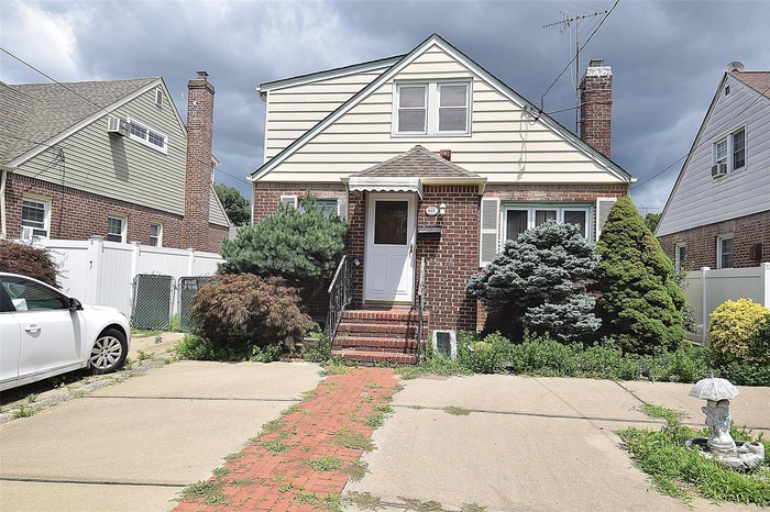 Bungalow-style home featuring entry steps, brick siding, and a chimney
