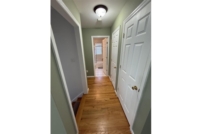 Corridor featuring baseboards and light wood-style flooring