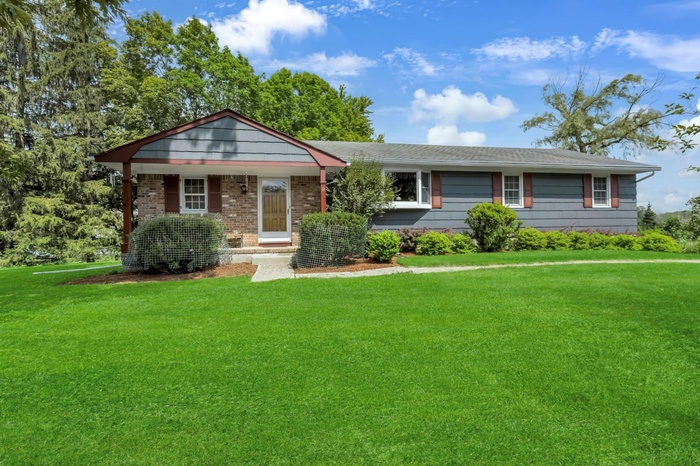 View of front of property with a front yard and brick siding
