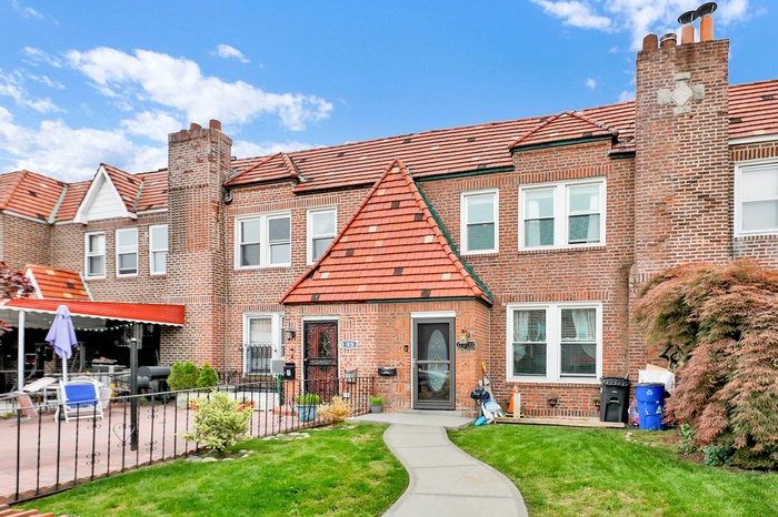 Townhome / multi-family property featuring brick siding and a chimney