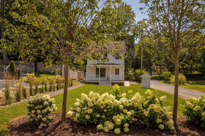 View of front of home featuring covered porch and a front lawn