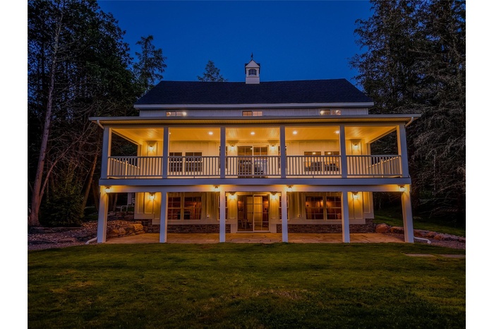 Rear view of property with a patio area, a lawn, roof with shingles, and a chimney