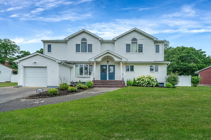 View of front of property with asphalt driveway, a garage, and french doors