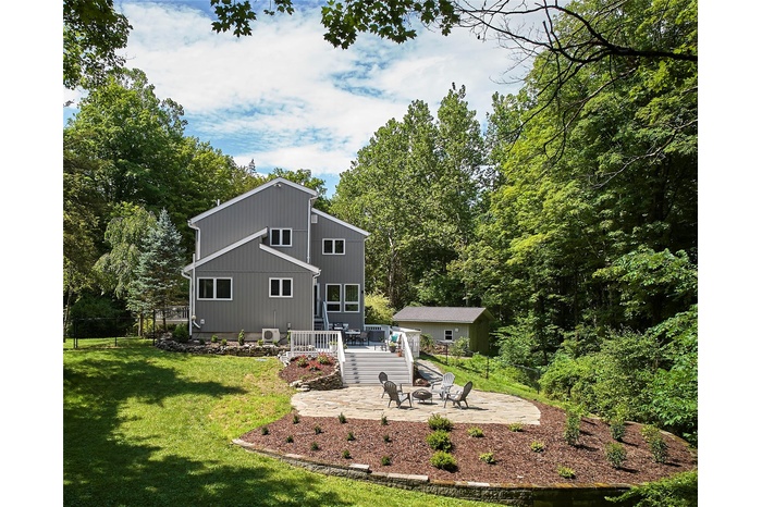 Back of house with a patio, a wooden deck, and a fire pit