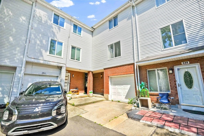 View of front of house featuring an attached garage, brick siding, and driveway