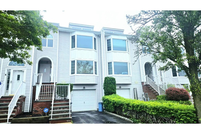 Townhome / multi-family property featuring asphalt driveway and an attached garage