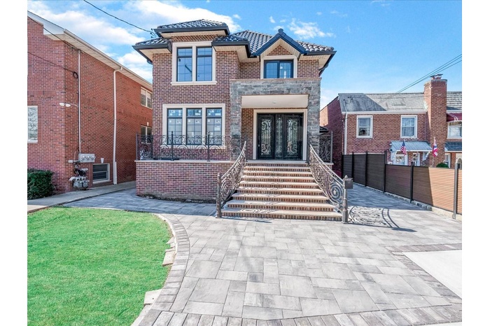 View of front of house with a tiled roof, french doors, and stone siding