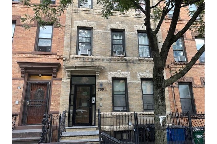 View of front facade featuring brick siding and a fenced front yard