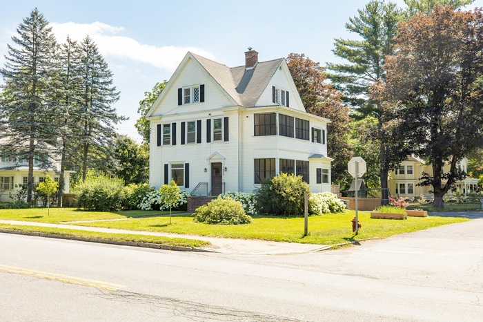 View of front of property with a chimney and a front lawn