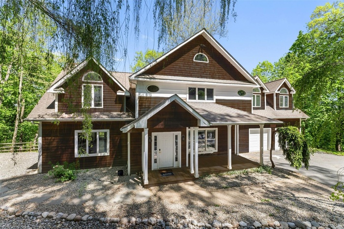 View of front of home with covered porch, driveway, and a garage