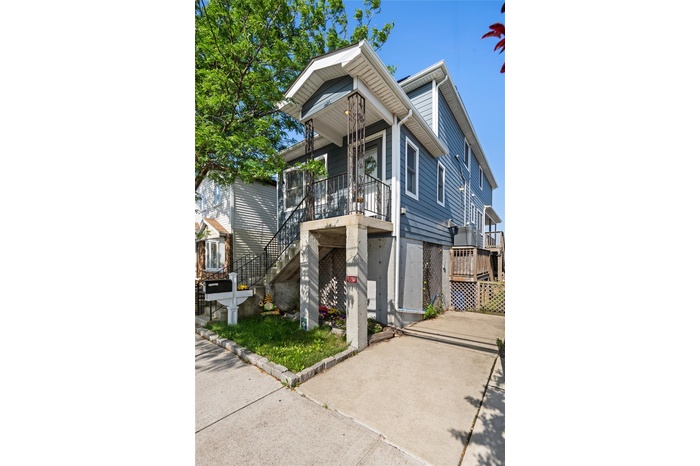 View of front of house with stairway and a porch