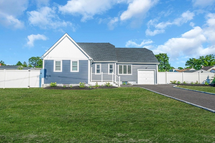 View of front facade featuring asphalt driveway, a garage, and a shingled roof