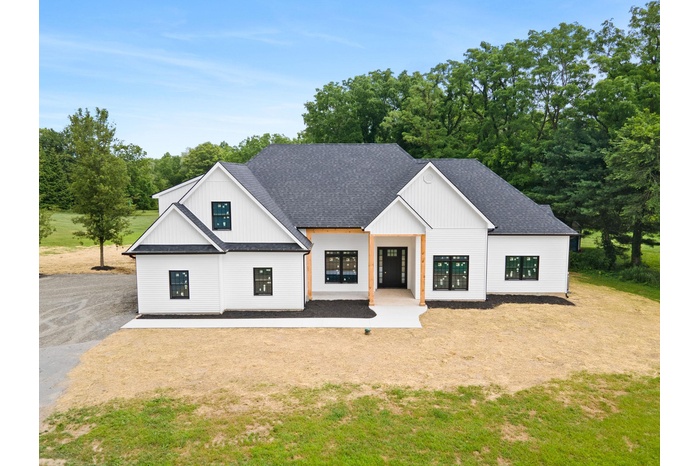 Modern farmhouse featuring roof with shingles