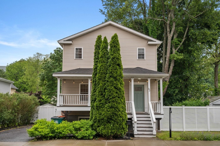 Traditional home featuring covered porch and roof with shingles