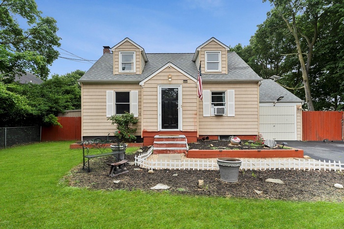 New england style home with entry steps, a shingled roof, and a chimney