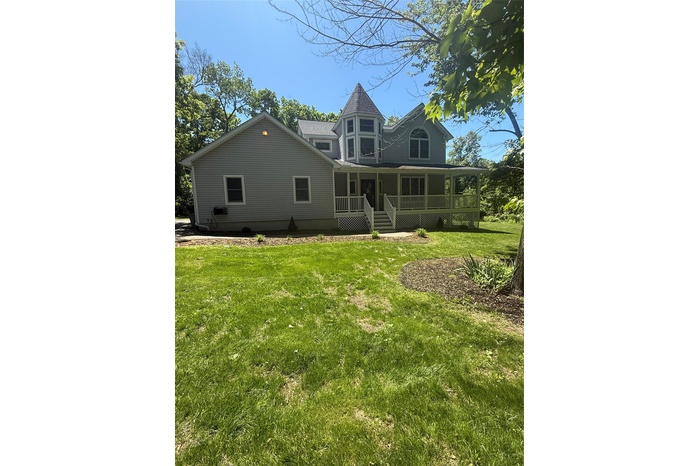 welcome home  with a wrap around porch and a yard
