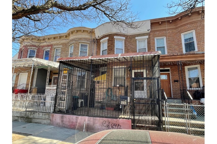 Townhome / multi-family property featuring brick siding, a fenced front yard, and a gate