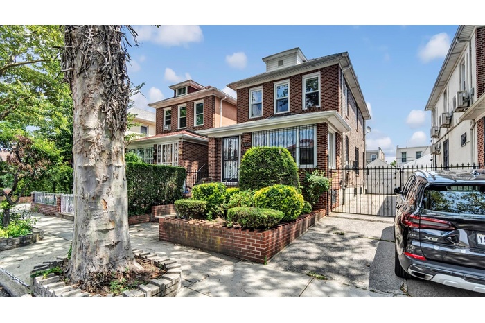 American foursquare style home featuring brick siding and a gate