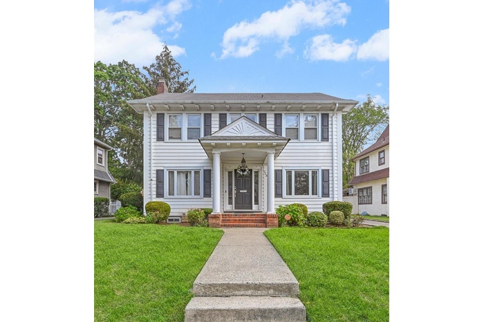 View of front of property featuring a chimney and a front lawn