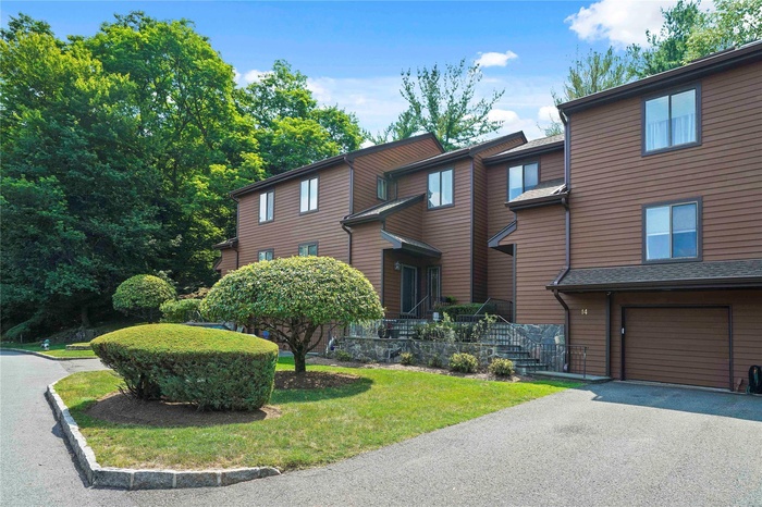 View of property with an attached one car garage.