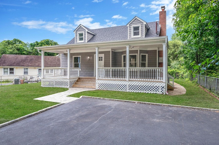 Cape cod-style house with a porch, roof with shingles, and a chimney