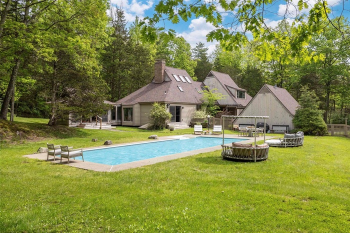 Outdoor pool featuring view of wooded area