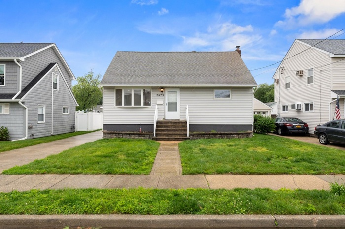 Bungalow-style home featuring a front lawn and a shingled roof