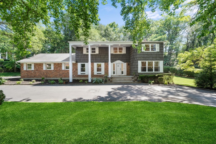 View of front of house with brick siding and a front lawn