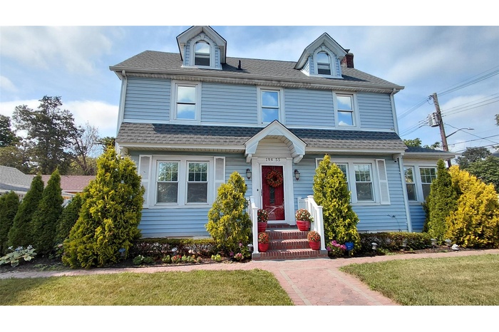 View of front of home with a front lawn and a shingled roof