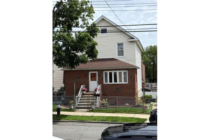 View of front of house featuring brick siding and a fenced front yard