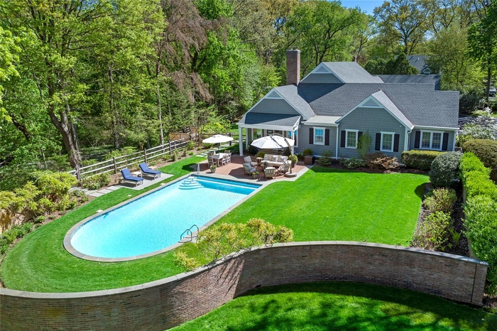 Outdoor dining area and patio next to a 20 x 38 gunite heated pool with bluestone coping, Jandy smart controls and a natural gas heater.