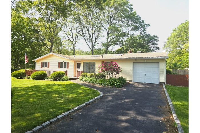 Ranch-style house featuring driveway, an attached garage, and a deck