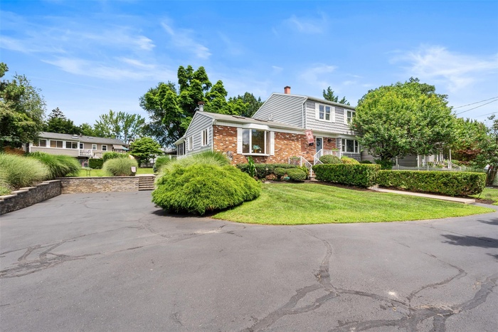 Driveway View featuring front lawn, Stone walls & steps