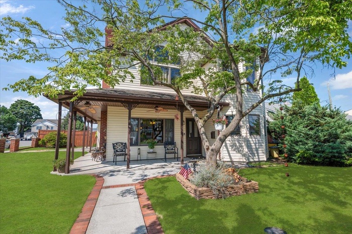 View of front of home featuring a ceiling fan, a patio area, and a chimney