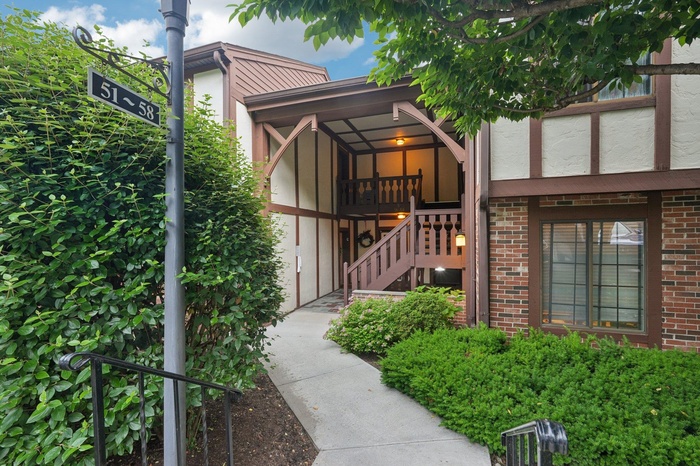 Property entrance featuring brick siding and stucco siding