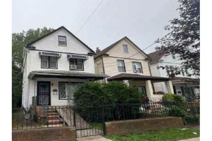 View of front facade with a fenced front yard, a gate, and covered porch