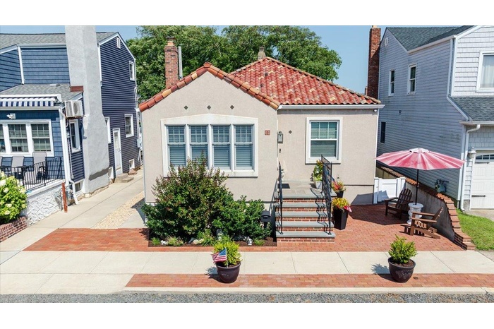 View of front of home with stucco siding and a patio