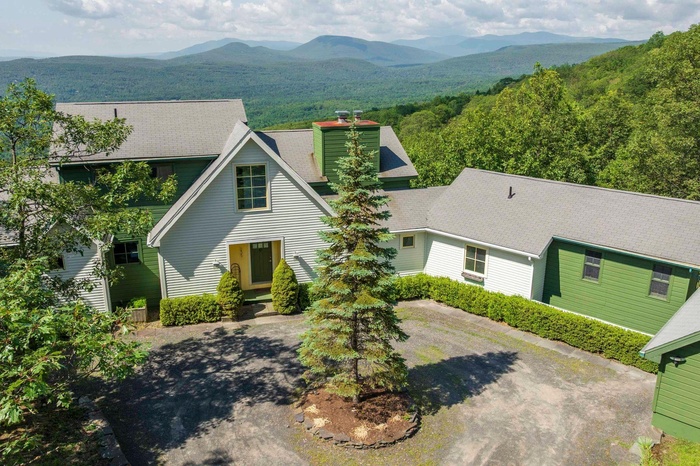 View of front of home with a mountain view and circular driveway.