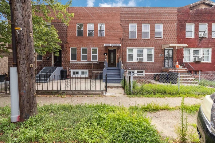 Traditional-style home featuring brick siding and a fenced front yard