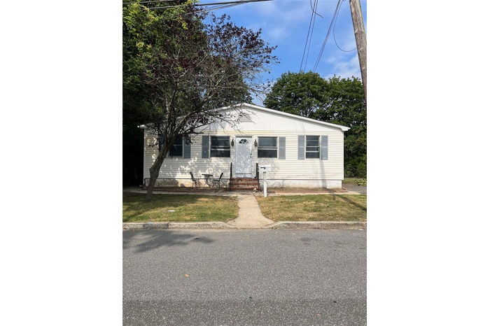 View of front facade with entry steps and a front yard