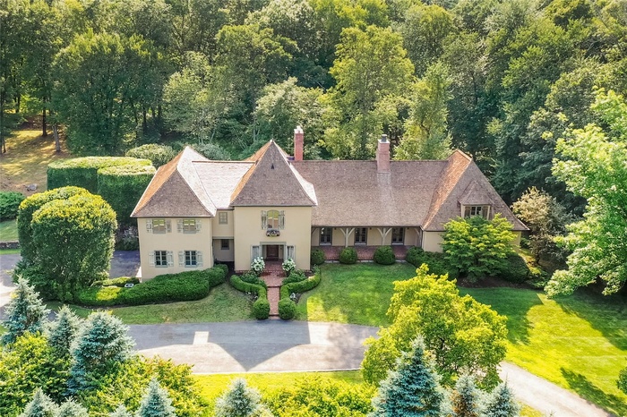 Aerial view of property and surrounding area featuring a forest