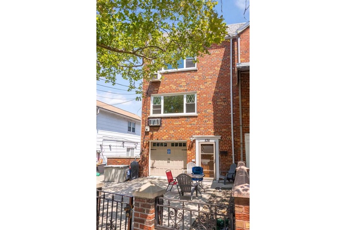 Back of house featuring brick siding and an attached garage