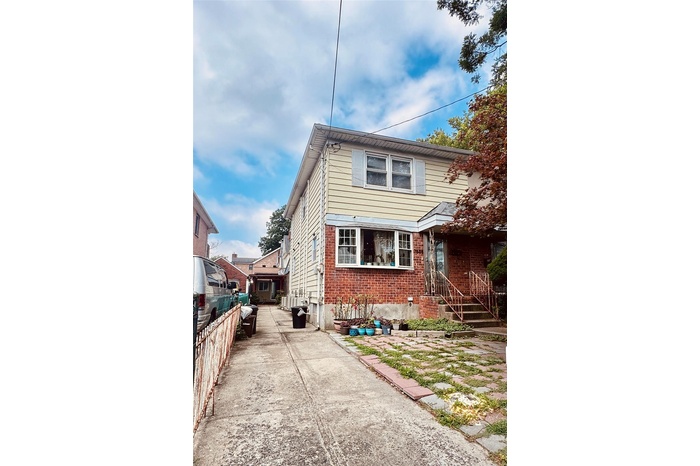 View of front facade featuring brick siding and concrete driveway