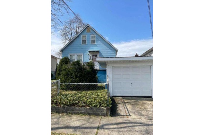 View of front of house featuring an attached garage, fence, and concrete driveway