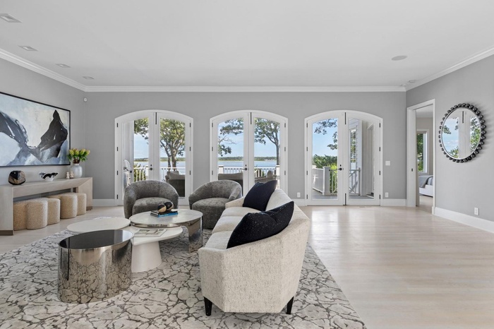 Living room with french doors, arched walkways, crown molding, and wood finished floors
