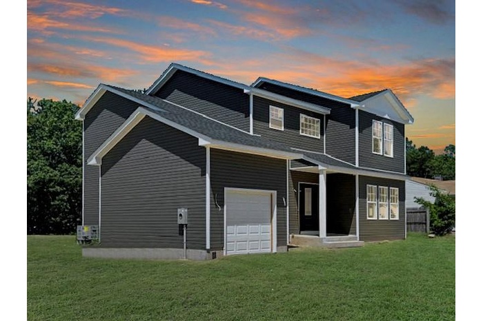 View of front of property with a lawn and a garage